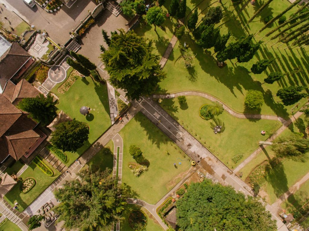 Aerial image of a landscaped garden with trees, pathways, and a house.