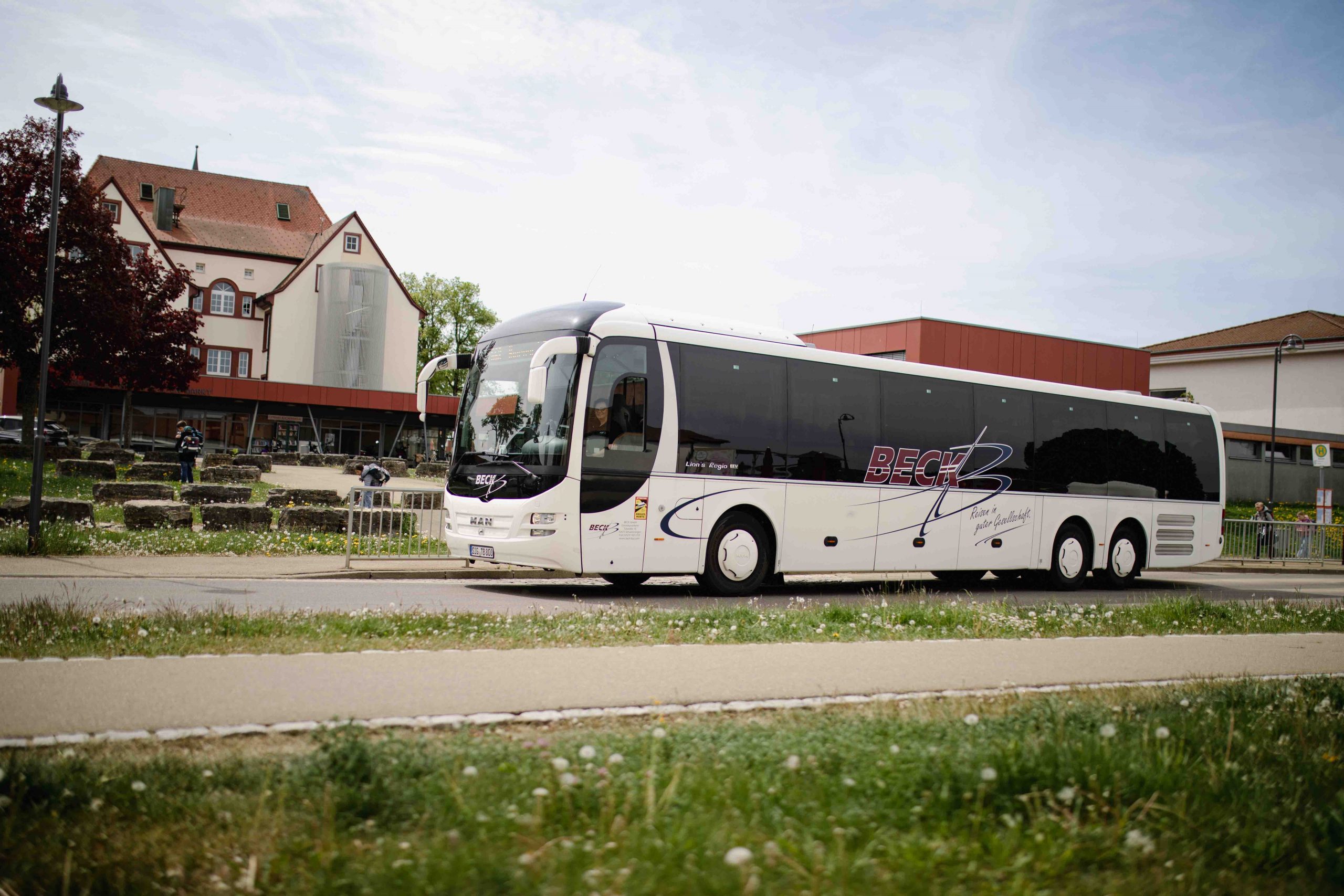Bus steht an einer Schule, an dessen Bushaltestelle.